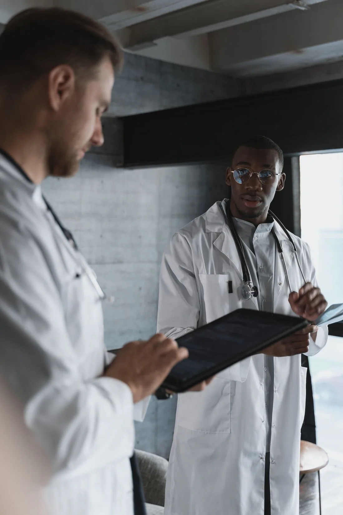 Two healthcare professionals discussing their work with a digital tablet